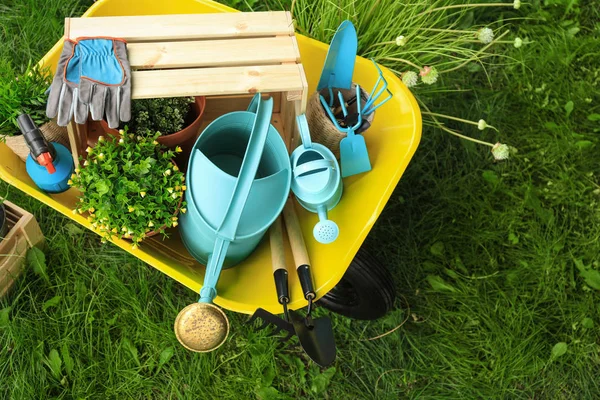 Composição com ferramentas de jardinagem na grama verde, vista acima — Fotografia de Stock