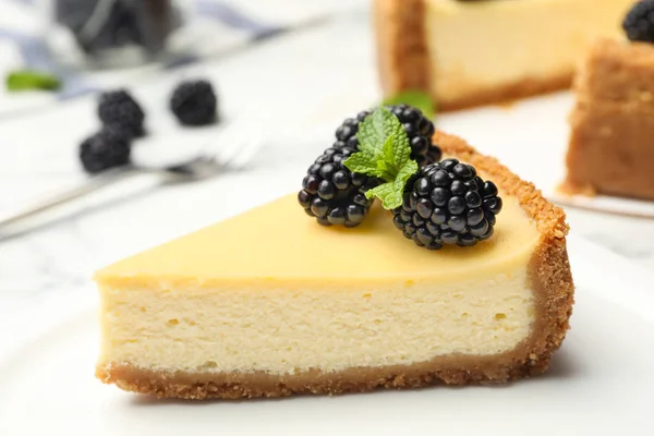 Piece of delicious cheesecake decorated with blackberries on table — Stock Photo, Image