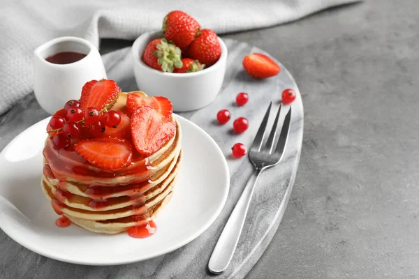 Tasty pancakes with berries served on grey table — Stock Photo, Image