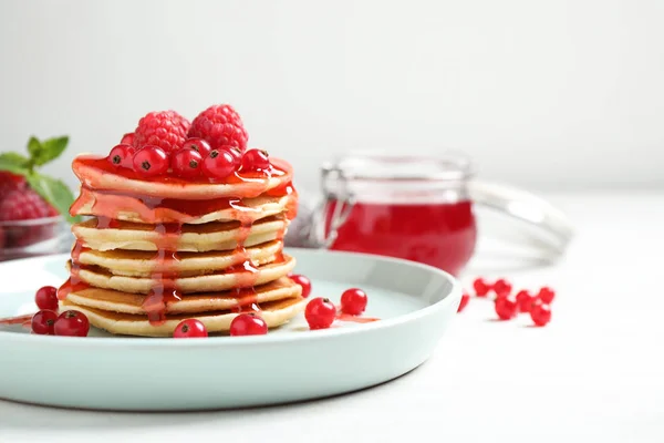 Pancake lezat dengan buah beri segar dan sirup di atas meja putih — Stok Foto