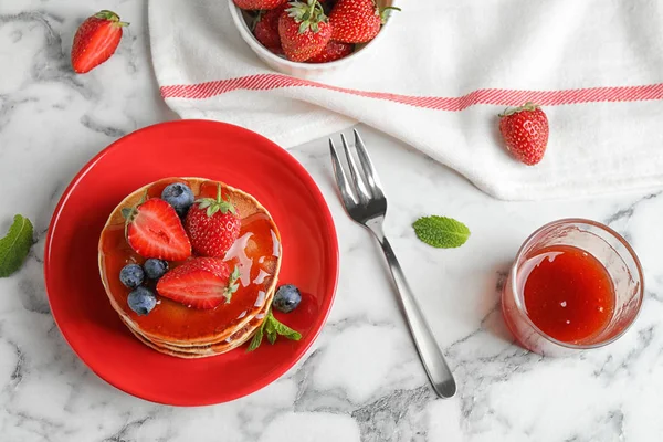 Deliciosas panquecas com bagas frescas e xarope servido em mesa de mármore branco, flat lay — Fotografia de Stock