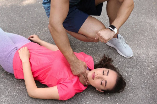 Genç adam sokakta baygın kadının nabzını kontrol