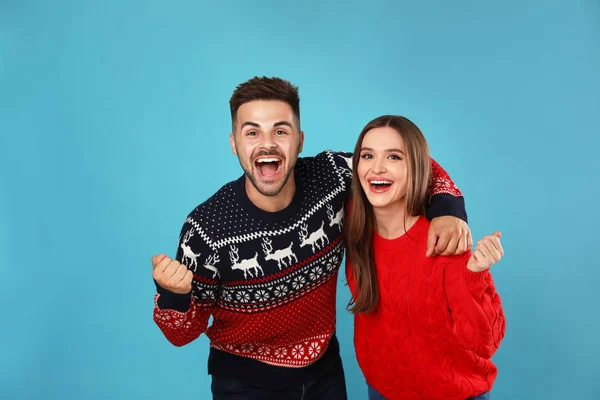 Pár visel karácsonyi pulóverek, kék háttér — Stock Fotó