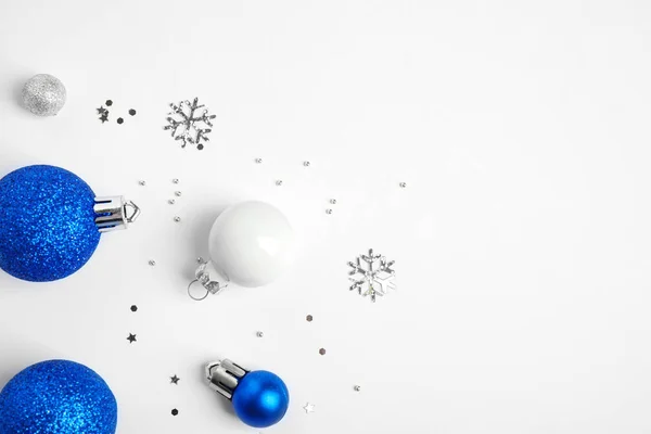 Barevné vánoční kuličky a jiskfle na bílém pozadí, pohled shora — Stock fotografie