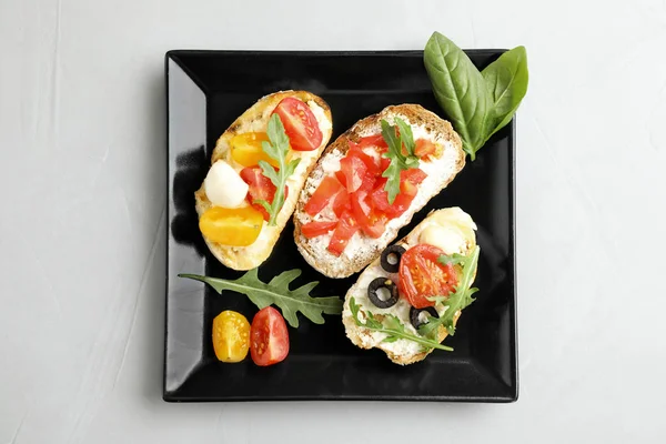 Bord van heerlijke tomaten bruschette op lichtgrijze achtergrond, bovenaanzicht — Stockfoto