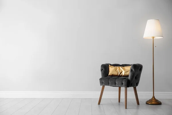 Elegante habitación interior con sillón cómodo, lámpara de pie cerca de la pared de luz, espacio para el texto —  Fotos de Stock