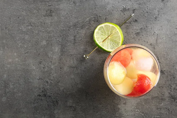 Glas meloen en watermeloen bal cocktail met limoen op grijze tafel, platte lag. Ruimte voor tekst — Stockfoto