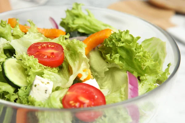 Ciotola di gustosa insalata greca fresca sul tavolo, primo piano — Foto Stock