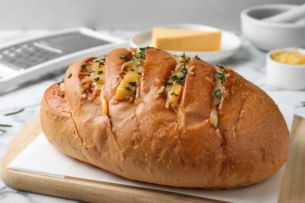 Delicioso pão de alho caseiro com ervas e queijo na mesa, close-up — Fotografia de Stock