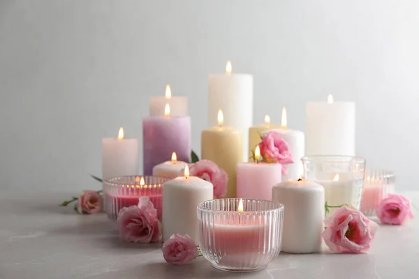 Composição com velas acesas na mesa contra fundo claro — Fotografia de Stock