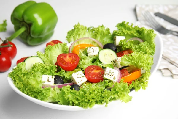 白いテーブルの上においしい新鮮なギリシャのサラダ、クローズアップ — ストック写真