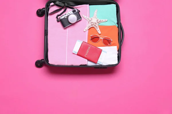 打开手提箱与海滩对象在粉红色背景，顶视图 — 图库照片