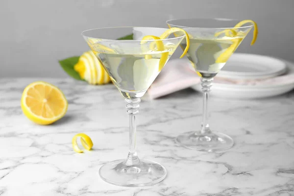 Copas de limón gota martini cóctel con ralladura en la mesa de mármol sobre fondo gris — Foto de Stock