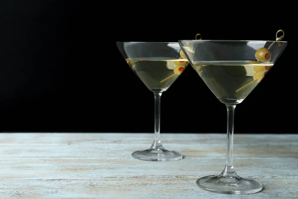 Glas klassisk Dry Martini med Oliver på träbord mot svart bakgrund. Utrymme för text — Stockfoto