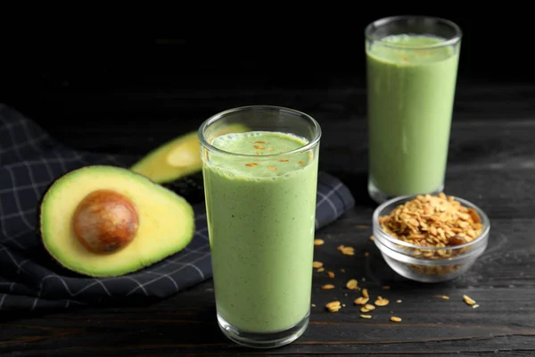 Lunettes de smoothie savoureux avec avocat et flocons d'avoine sur table en bois noir — Photo