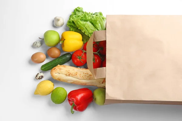 Paper bag with different groceries on white background, top view — Stock Photo, Image