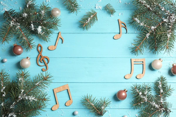 파란색 나무 배경에 전나무 가지와 노트로 만든 프레임, 텍스트 공간이있는 상단보기. 크리스마스 음악 컨셉 — 스톡 사진