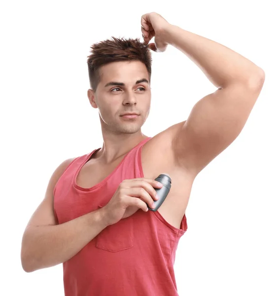 Hombre joven aplicando desodorante a la axila sobre fondo blanco — Foto de Stock