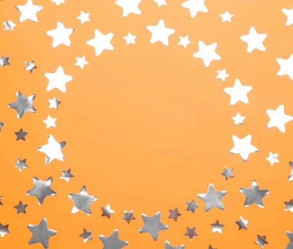 Marco hecho de estrellas de confeti con espacio para texto sobre fondo naranja, vista superior. Celebración de Navidad —  Fotos de Stock