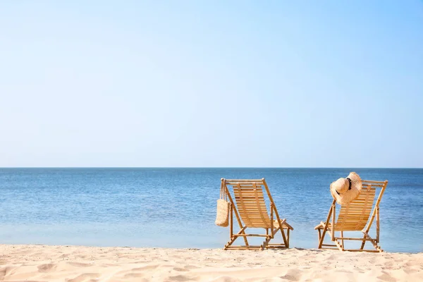 海の近くの砂浜の木製のデッキの椅子 — ストック写真
