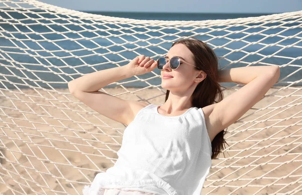 Genç bir kadın plajda hamakta dinleniyor. — Stok fotoğraf