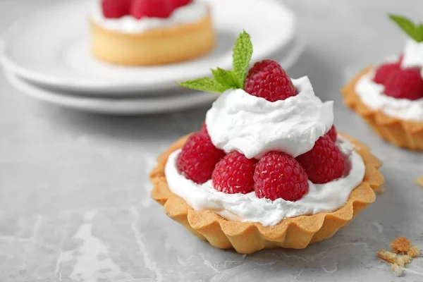 Tarts with raspberries on marble table, closeup. Delicious pastries — Stock Photo, Image