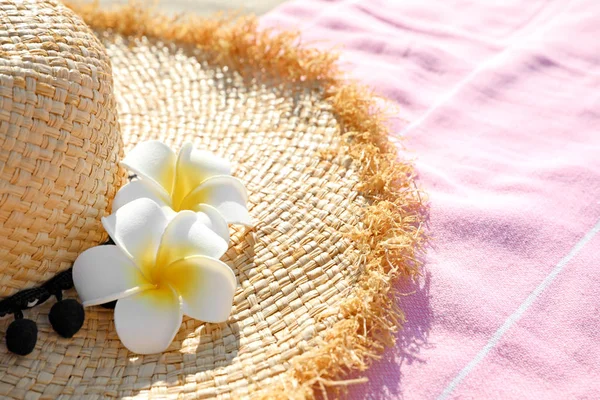 Sombrero de paja y toalla rosa al aire libre. Accesorios de playa —  Fotos de Stock