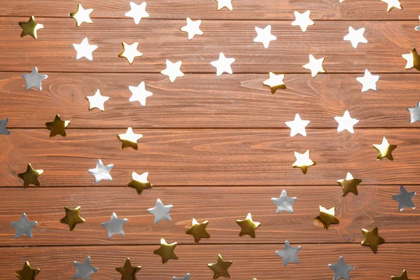 Marco hecho de estrellas de confeti con espacio para texto sobre fondo de madera, vista superior. Celebración de Navidad —  Fotos de Stock