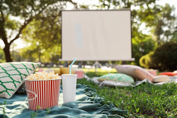 Pipocas e bebida na grama verde no cinema ao ar livre. Espaço para texto — Fotografia de Stock