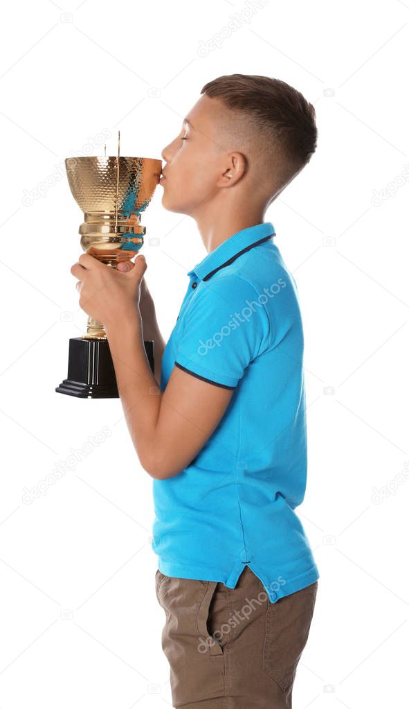 Happy boy kissing golden winning cup on white background