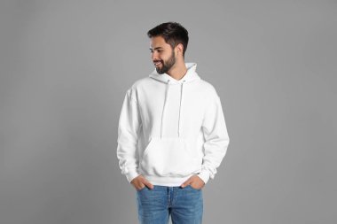 Gri arka planda kazak giyen genç adamın portresi. Tasarım için alay