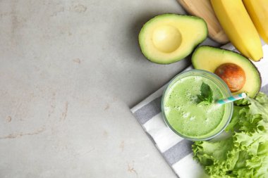 Gri masa üzerinde lezzetli avokado smoothie ile Düz yatıyordu kompozisyon. Metin için alan