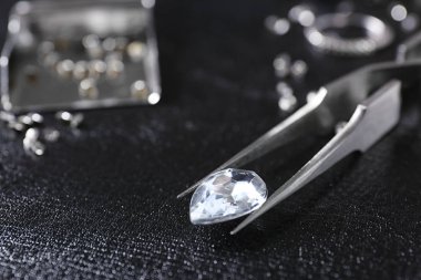 Siyah deri yüzeyde mücevher ve cımbız