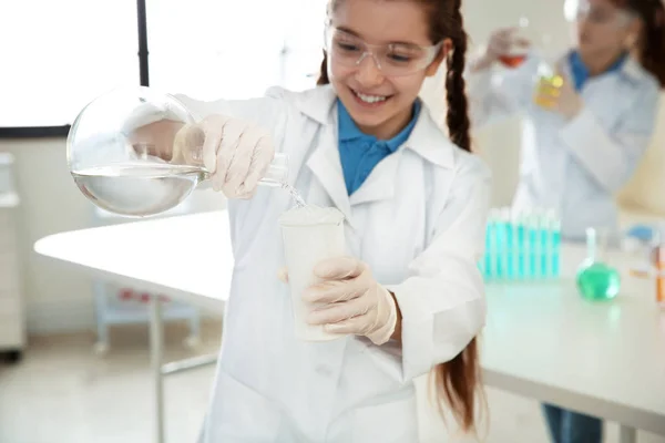 Schoolgirl gör experiment i kemi klass, närbild — Stockfoto