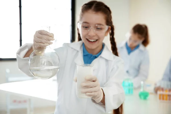 Schoolgirl gör experiment i kemi klass, närbild — Stockfoto