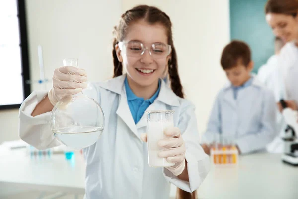 Schoolgirl gör experiment i kemi klass, närbild — Stockfoto