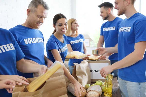 Equipo de voluntarios recogiendo donaciones de alimentos en interiores — Foto de Stock