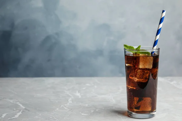 Refrescante bebida de soda con paja sobre mesa gris sobre fondo azul, espacio para texto — Foto de Stock