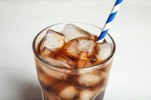 Vaso de refresco con cubos de hielo y paja sobre fondo blanco, primer plano — Foto de Stock