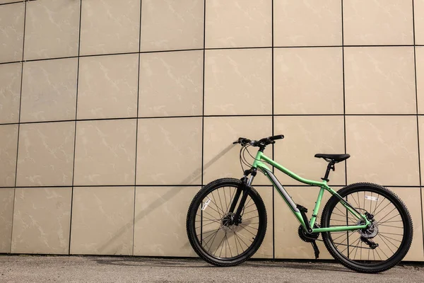 Современный велосипед возле бежевой стены на открытом воздухе. Пространство для текста — стоковое фото