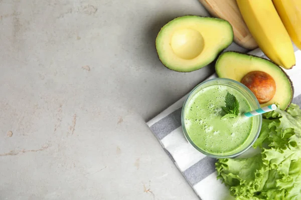 Gri masa üzerinde lezzetli avokado smoothie ile Düz yatıyordu kompozisyon. Metin için alan