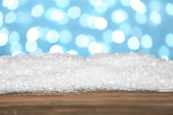 Montón de nieve en la superficie de madera sobre fondo azul. Temporada de Navidad — Foto de Stock