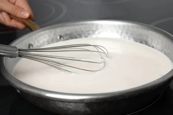 Kadın soba, closeup tavada lezzetli kremalı sos pişirme — Stok fotoğraf