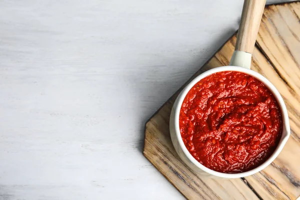 Heerlijke tomatensaus in pan op witte houten tafel, Top View. Ruimte voor tekst — Stockfoto