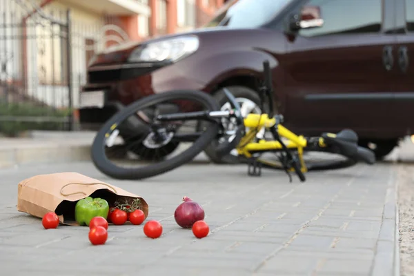 Bicicleta caída después de accidente de coche al aire libre, se centran en verduras dispersas — Foto de Stock