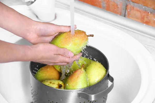 Жінка миє свіжі стиглі груші в кухонній мисці, крупним планом — стокове фото