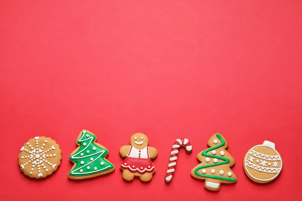 Composição de leigos plana com saborosos biscoitos caseiros de Natal no fundo vermelho, espaço para texto — Fotografia de Stock