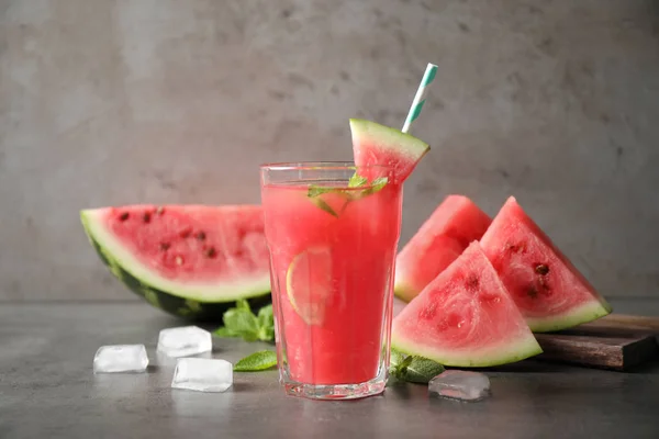 Vaso de sabrosa bebida refrescante con sandía sobre mesa gris —  Fotos de Stock