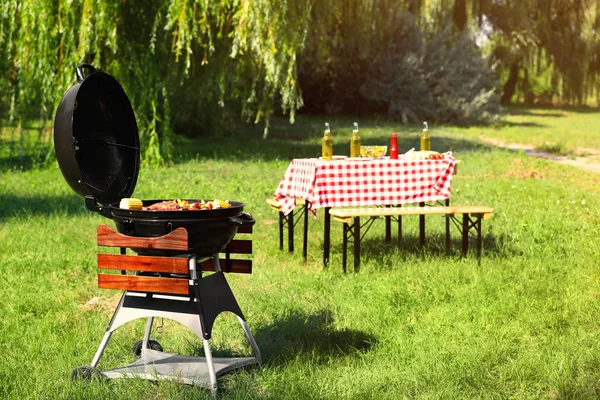 Modern barbecue grill with tasty food in park