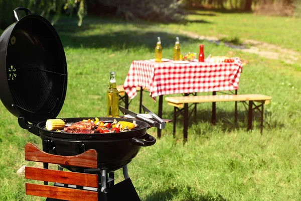 Barbecue moderno con cibo gustoso nel parco — Foto Stock